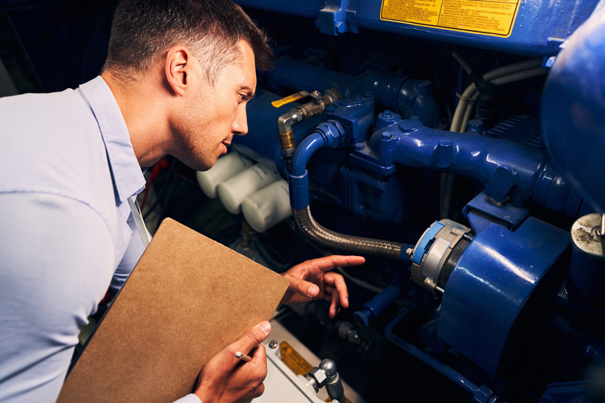 Serious focused qualified Caucasian data center male worker inspecting power supply equipment