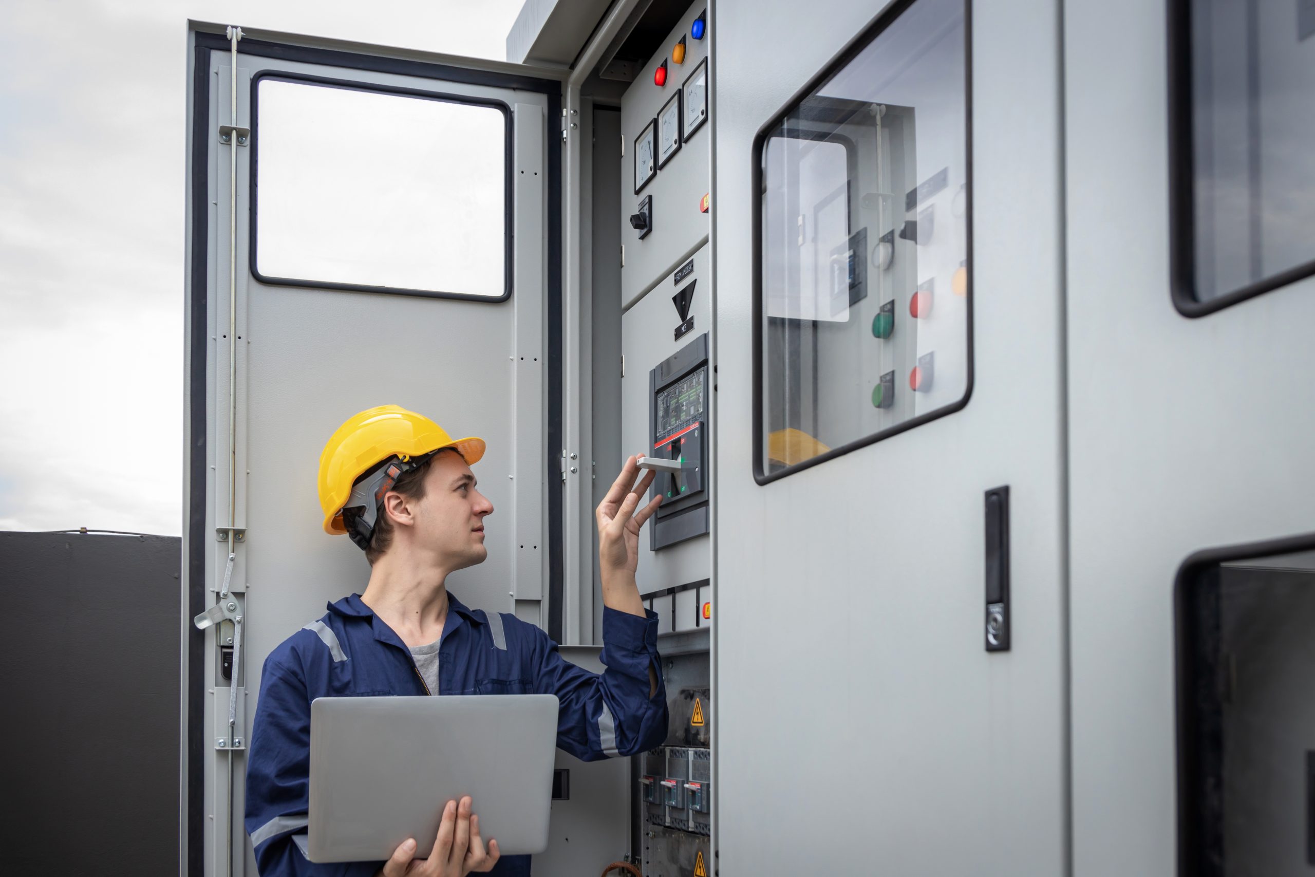 Electrical engineer working in control room. Electrical engineer man checking Power Distribution Cabinet in the control room